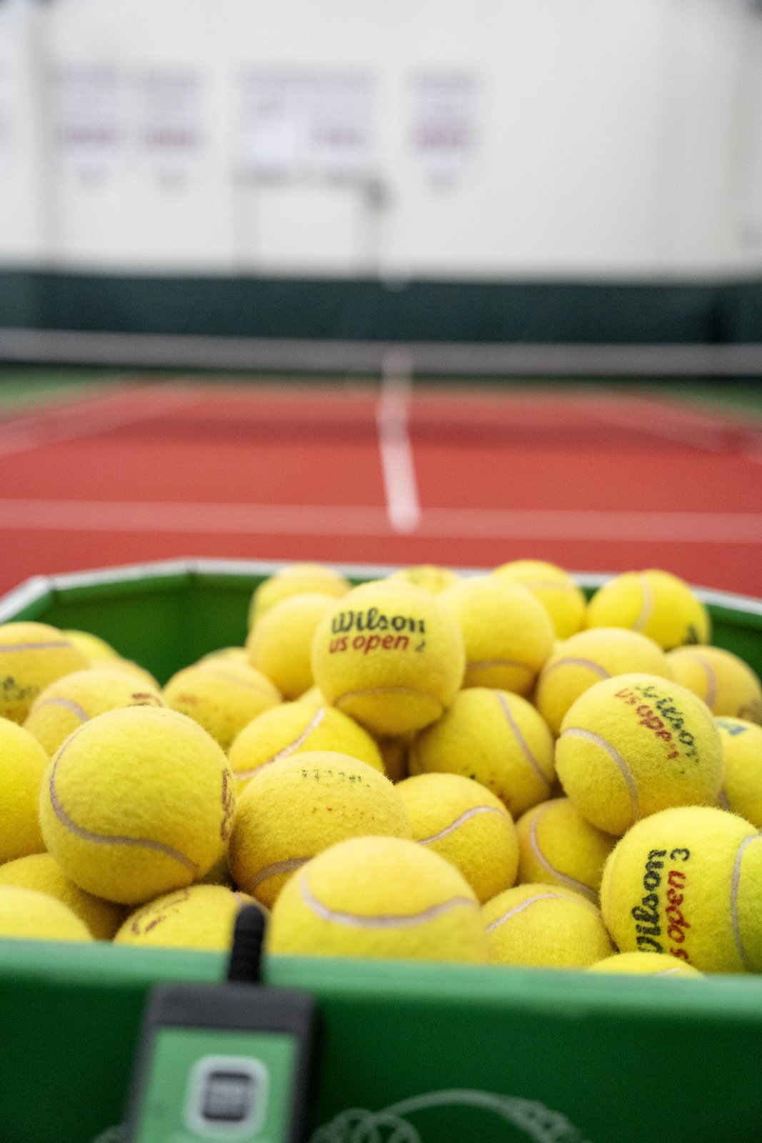 Basket of tennis balls on the finished indoor court at OU