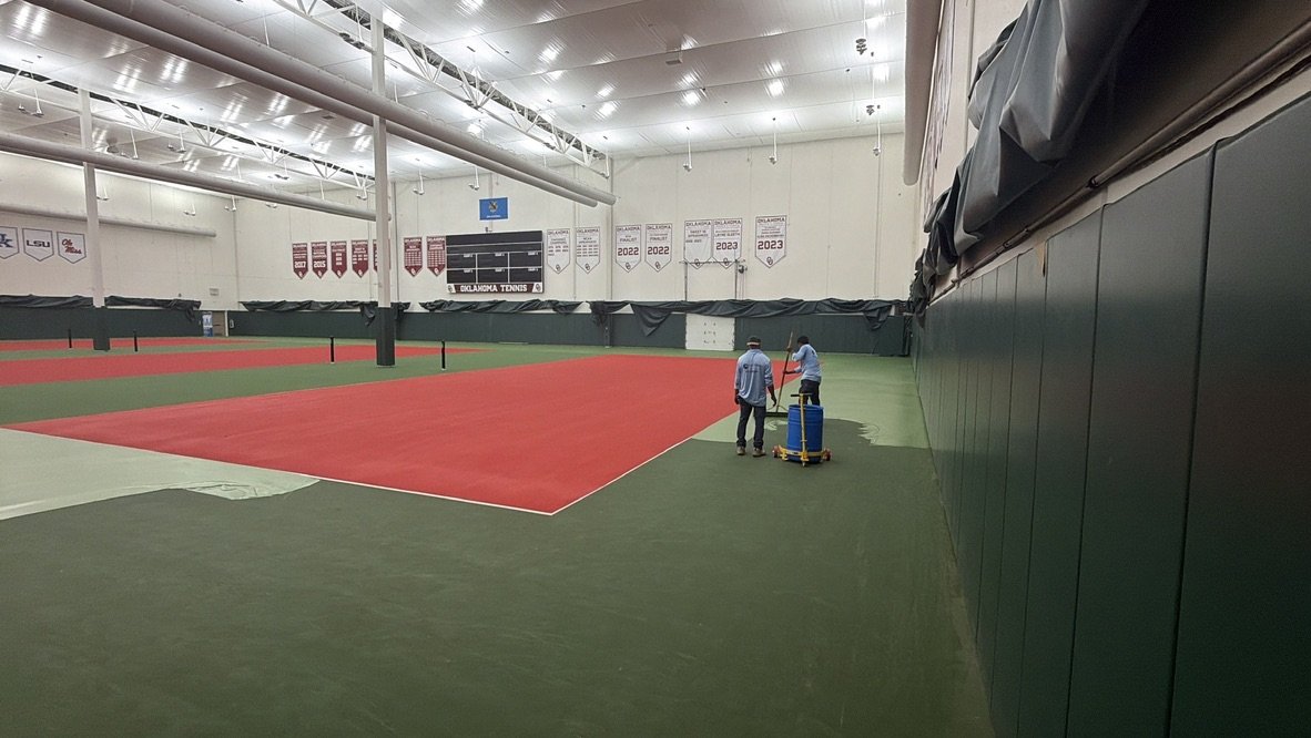 Indoor court at the Gregg Wadley facility with the red playing area freshly squeegeed and the green surround going on