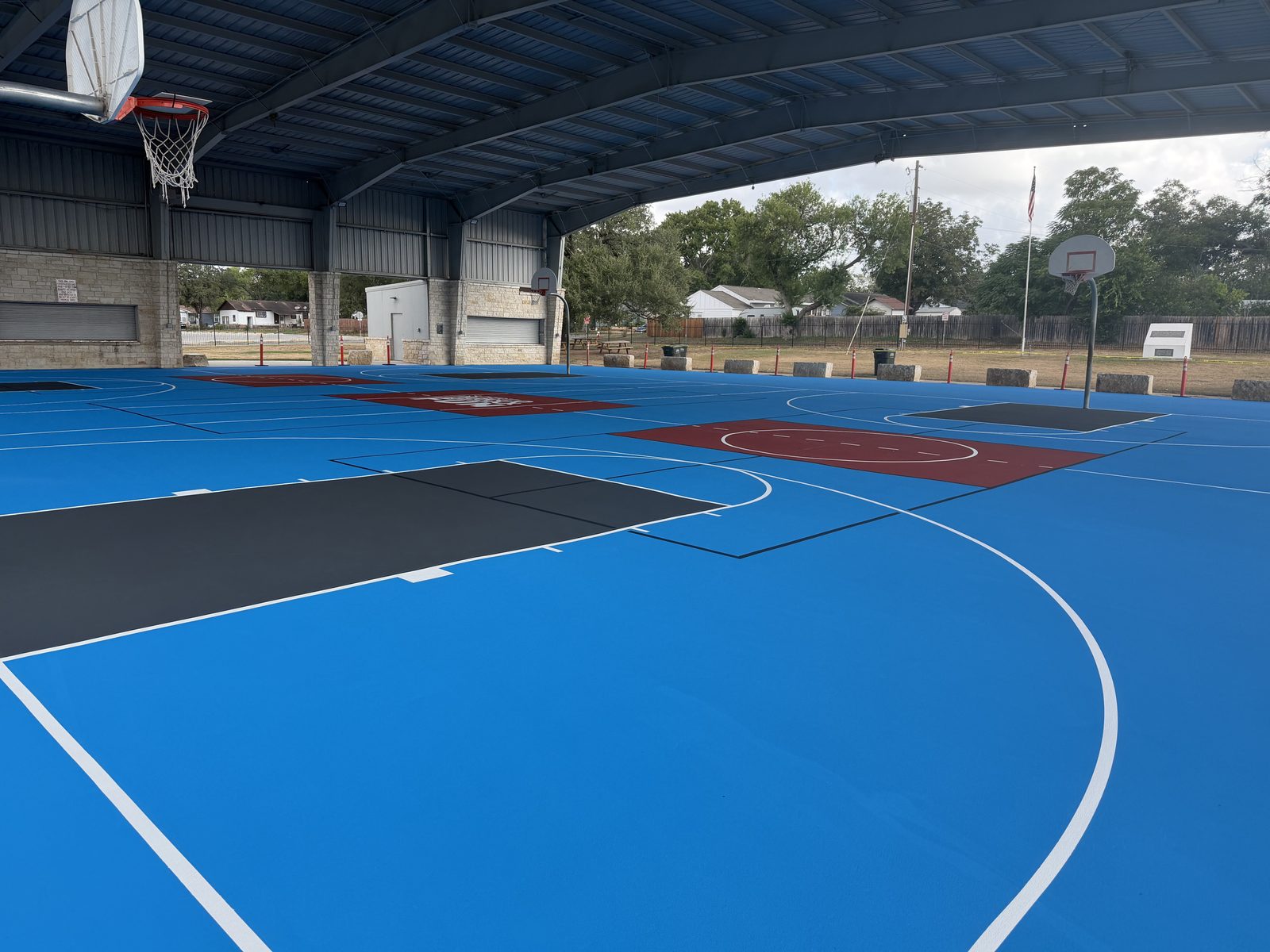 Light blue pickleball courts with brick red kitchens at Pickrell Park in Schertz, Texas
